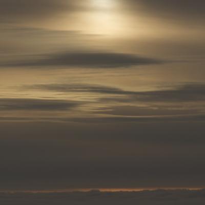 The sun in the clouds from the airplane.