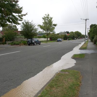 Large amounts of water flowing down the street.